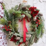 Ghirlanda di Natale in Rattan con Pino, Pigne, Stelle di Natale, Bacche e Fiocco Rosso – H50 x L54 cm